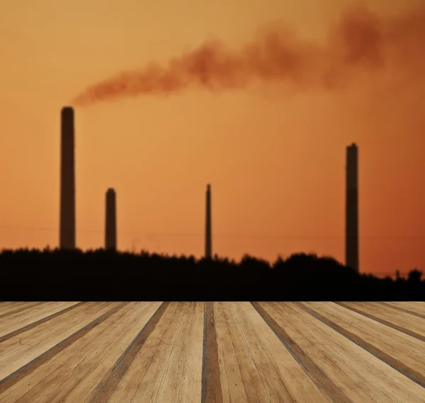 Industrial chimney stacks in natural landscape with wooden plank — Stock Photo, Image