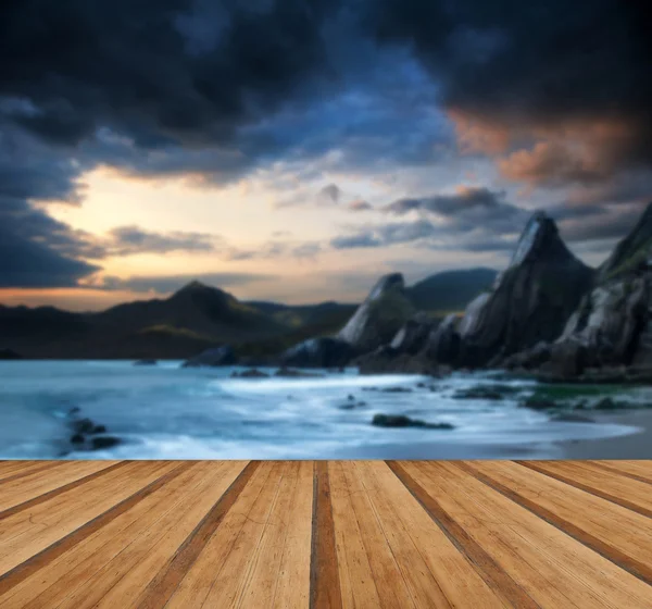 Hermoso paisaje de montañas y mar al atardecer con p de madera — Foto de Stock