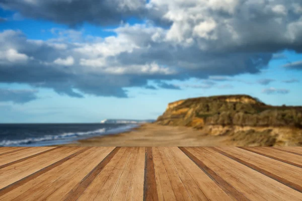 Paesaggio vivace tramonto sulla spiaggia e scogliere con tavole di legno f — Foto Stock