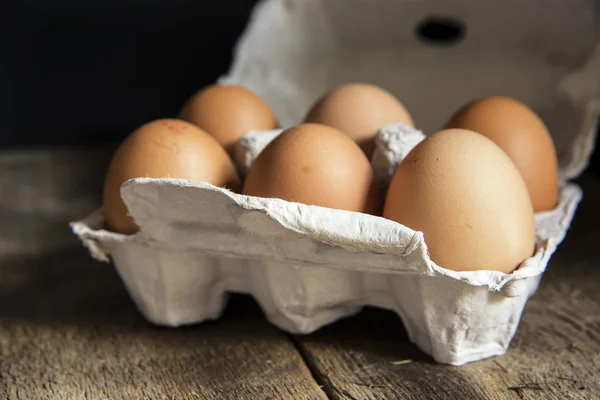 Huevos frescos en caja de huevos en luz natural de mal humor vintage retro st — Foto de Stock