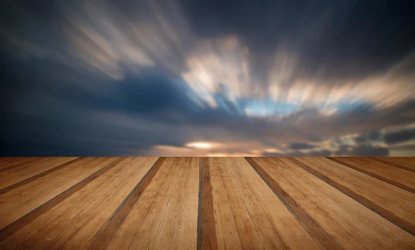 Изображение заката над океаном на деревянном плане — стоковое фото