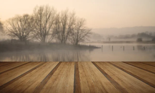 Paisaje de lago en niebla con sol resplandor al amanecer con madera p — Foto de Stock