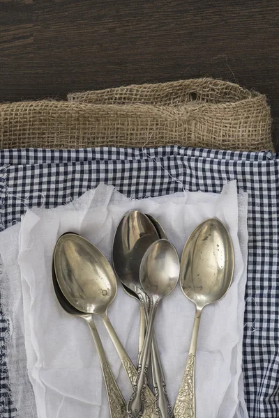 Vintage cutlery on cloths on rustic wooden background — Stock Photo, Image