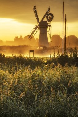 Stunning landscape of windmill and river at dawn on Summer morni clipart