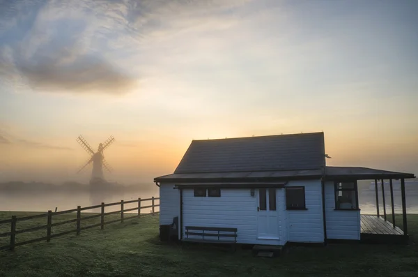 Stunning sunrise landscape over river house and foggy river with — Stock Photo, Image