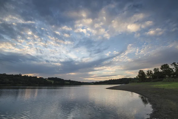 Dramatic stormy sunset over calm lake in Summer in English count — Stock Photo, Image