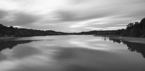 Larga exposición imagen de paisaje en blanco y negro del lago al atardecer —  Fotos de Stock