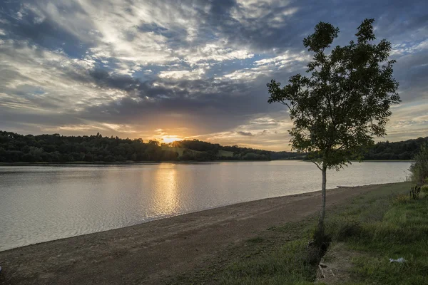 Drammatico tramonto tempestoso sul lago calmo in estate in inglese contare — Foto Stock