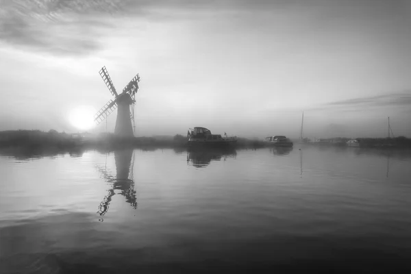 Stunnnig paisagem de moinho de vento e rio ao amanhecer em preto e wh — Fotografia de Stock