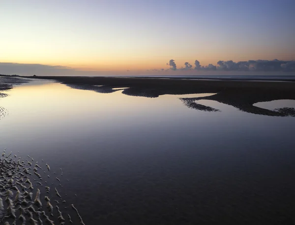 Belo nascer do sol tranquilo sobre a praia da maré baixa — Fotografia de Stock