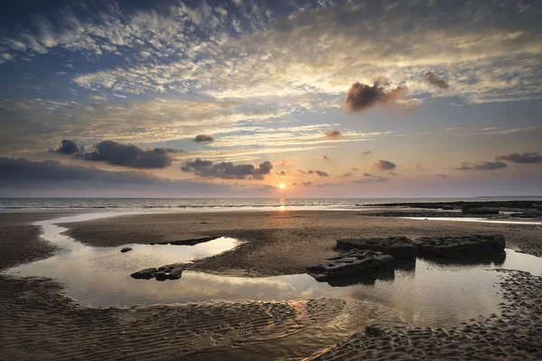 Atemberaubende, lebendige Landschaft bei Sonnenuntergang über der Dunraven Bay in Wales — Stockfoto