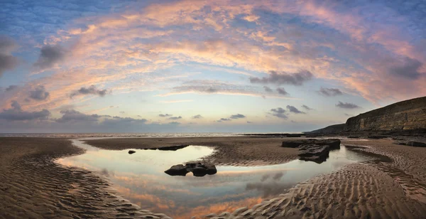 Stunning vibrant panorama sunset landscape over Dunraven Bay in — Stock Photo, Image