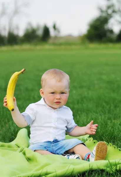 Kind zeigt Banane — Stockfoto