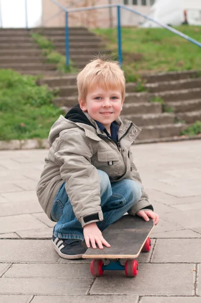 Smilende gutt med skateboard – stockfoto