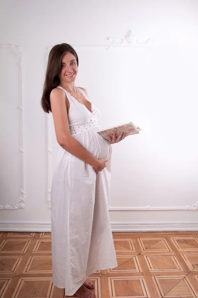 Terhes nő stúdióban könyv — Stock Fotó