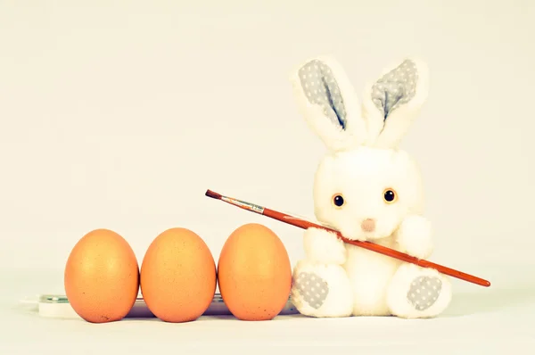 Funny bunny with eggs and brush — Stock Photo, Image