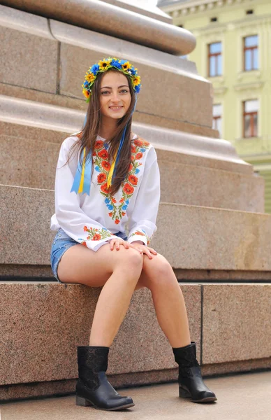 Szép ukrán lány ül a emlékmű — Stock Fotó