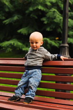 Küçük çocuk bankta standları