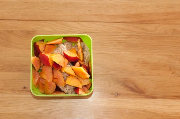 Kom met porrige en fruit voor het ontbijt — Stockfoto