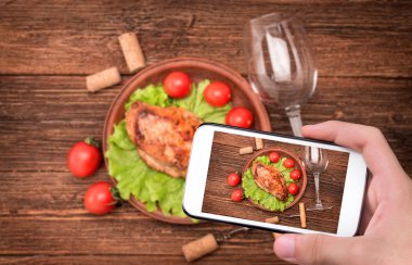 Fotoğraf çekme ellerini ızgara tavuk göğsü ile smartphone.