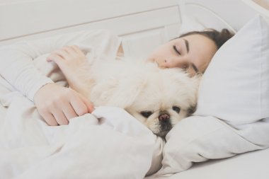 Kız ve köpeği yatakta.