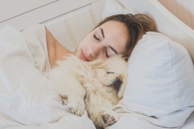 Kız ve köpeği yatakta.