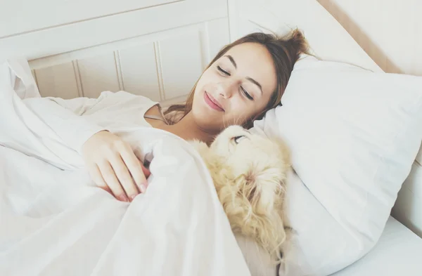 Lány és a kutya az ágyban. — Stock Fotó
