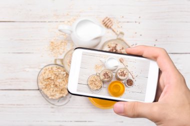 Eller fotoğraf smoothies smartphone ile yulaf ezmesi ile alarak.