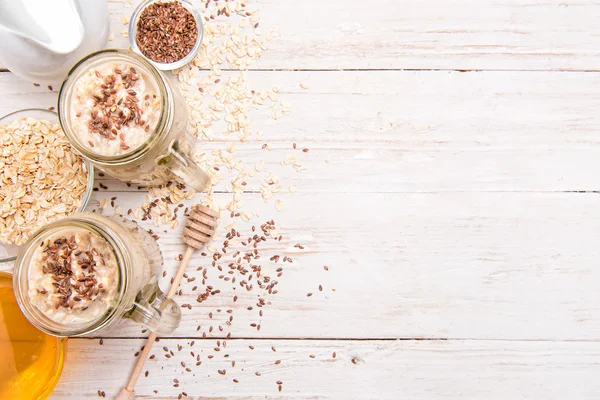 Batidos con harina de avena, semillas de lino en frascos de vidrio sobre un fondo de madera . —  Fotos de Stock