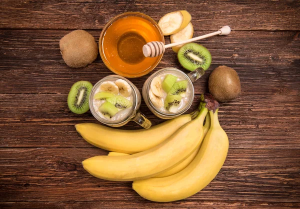 Smoothies mit Haferflocken, Banane, Kiwi in Glasgläsern auf Holzgrund. — Stockfoto