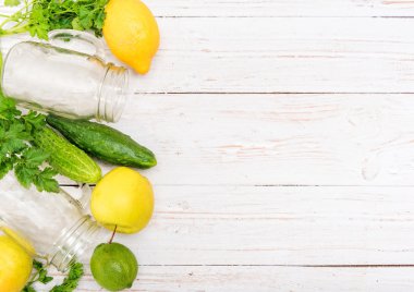 Smoothies ile salatalık, elma, limon, maydanoz cam kavanozlar ahşap bir arka plan üzerinde. 