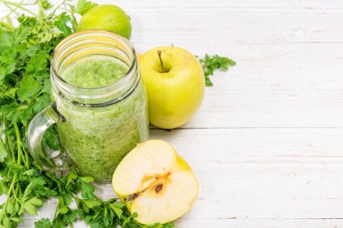 Smoothies ile elma, limon, maydanoz ahşap arka plan üzerinde kavanozların içinde. Pişirme kavramı.
