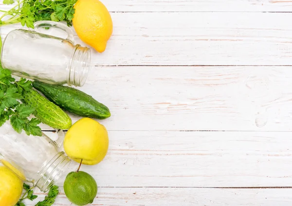 Smoothies au concombre, pomme, citron, persil dans des pots en verre sur un fond en bois . — Photo