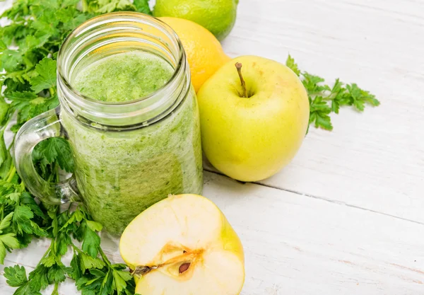 Frullati con mela, limone, prezzemolo in vasetti di vetro su fondo di legno. Concetto di cottura . — Foto Stock