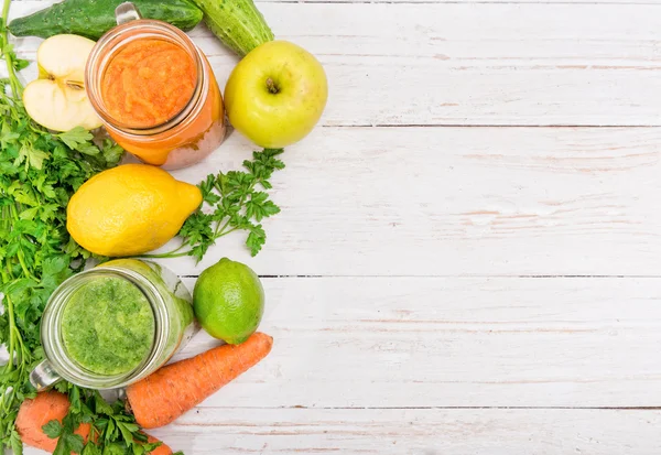 Smoothies vegetais em jarros de vidro em um fundo de madeira. Conceito de cozinhar . — Fotografia de Stock