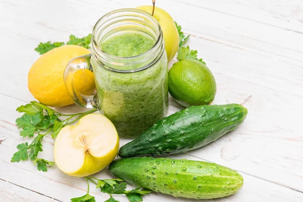 Frullati con cetriolo, mela, limone, prezzemolo in vasetti di vetro su fondo di legno . — Foto Stock