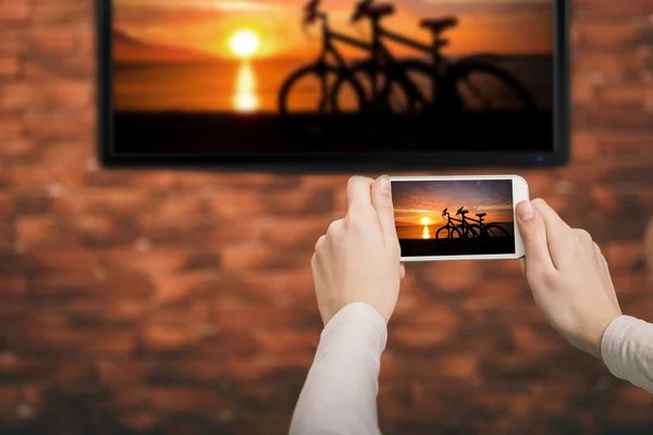 Nahaufnahme eines Smartphones ist mit einem Smart-TV verbunden. — Stockfoto