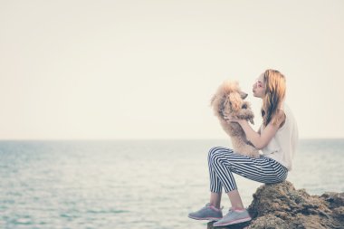 Genç kız denizde bir köpekle dinleniyor.