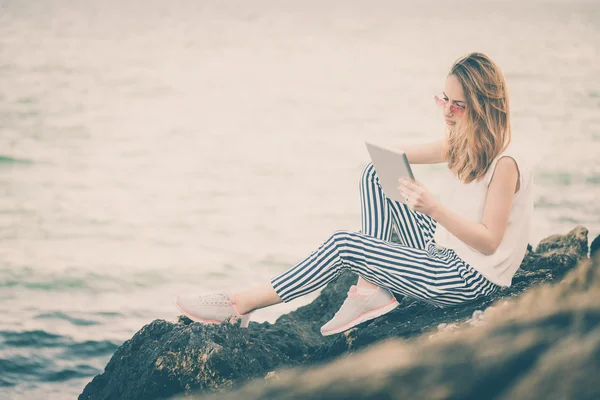 Flickan med en digital tablett vid havet. — Stockfoto
