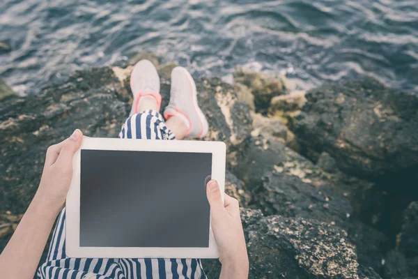Menina usando um tablet digital à beira-mar . — Fotografia de Stock