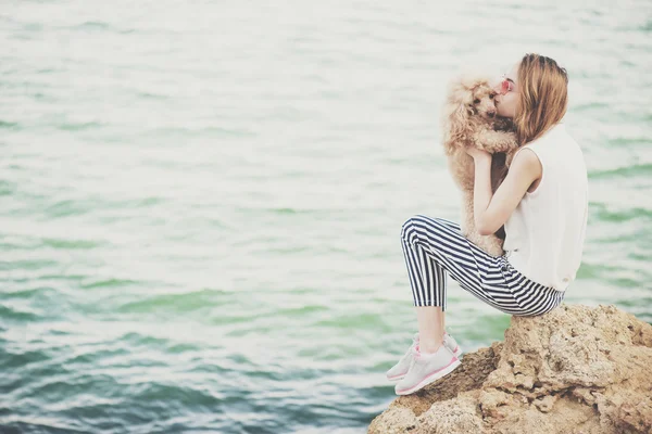 Young girl is resting with a dog on the sea. — Stock Photo, Image