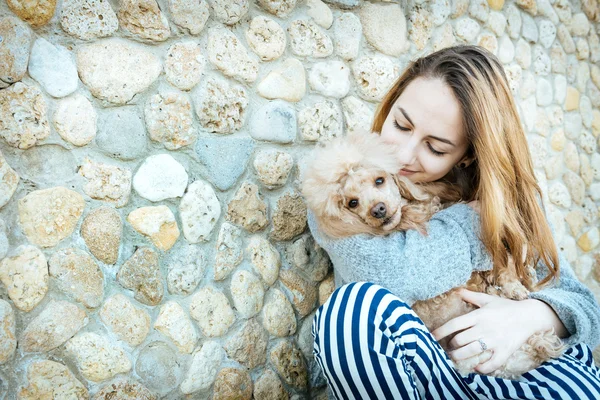 Ung flicka vilar med en hund på utomhus. — Stockfoto