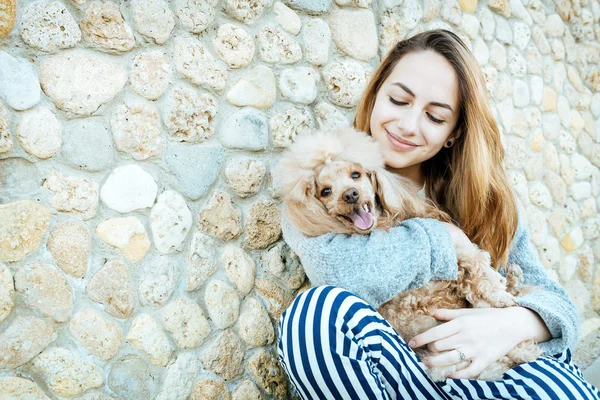 Ung flicka vilar med en hund på utomhus. — Stockfoto