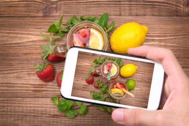 Çilek cam ile smartphone ile fotoğraf çekme ellerini iç.