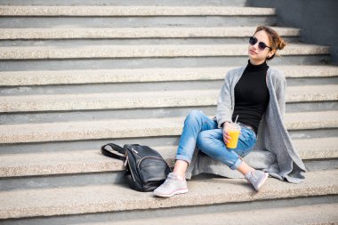 Güler yüzlü içme sokakta oturan genç güzel kadın,.