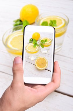 Eller fotoğraf limon alarak smartphone ile iç.