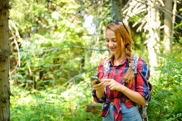 Randonneur jeune fille recherche les coordonnées GPS sur le smartphone  . — Photo