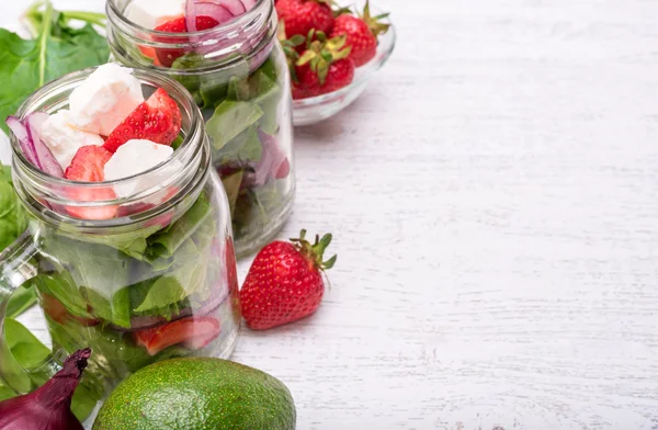 Homemade salad with spinach, strawberry and cheese in glass jar. — Stock Photo, Image