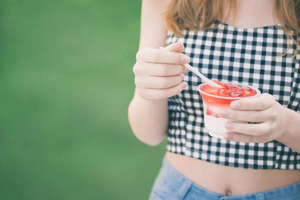Jong meisje eet dessert met aardbei . — Stockfoto