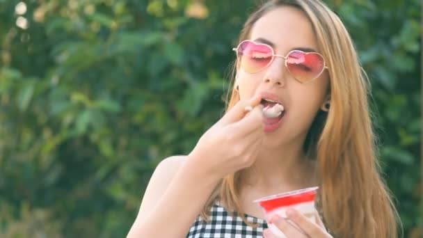 Mladá dívka jíst dezert s jahodami . — Stock video
